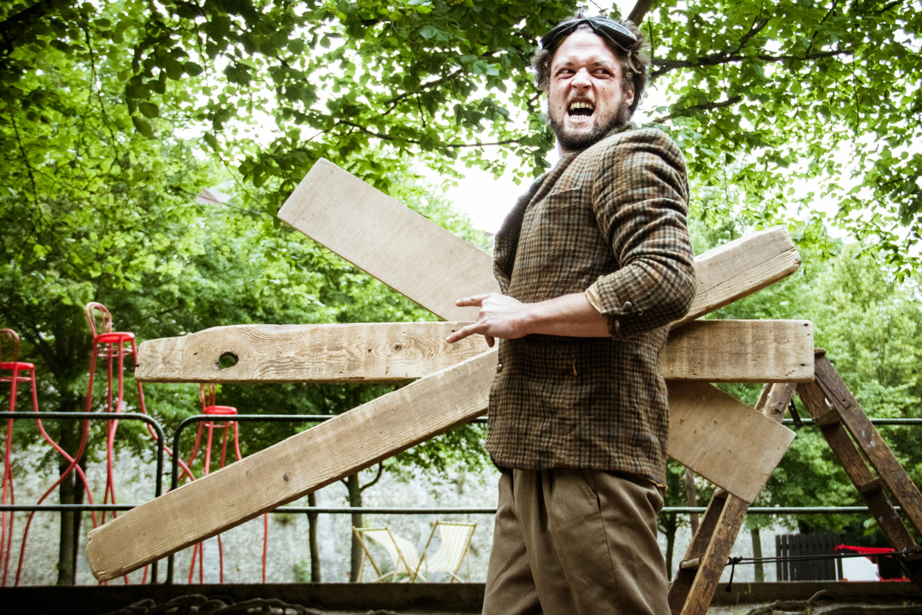 Homme portant des planches de bois à l’Espace culturel Angonia, Martres-Tolosane