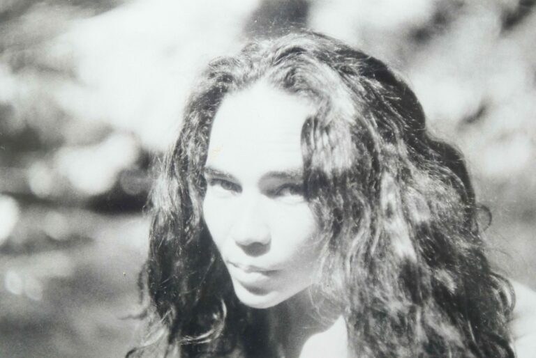 Portrait en noir et blanc d’une femme aux cheveux longs ondulés