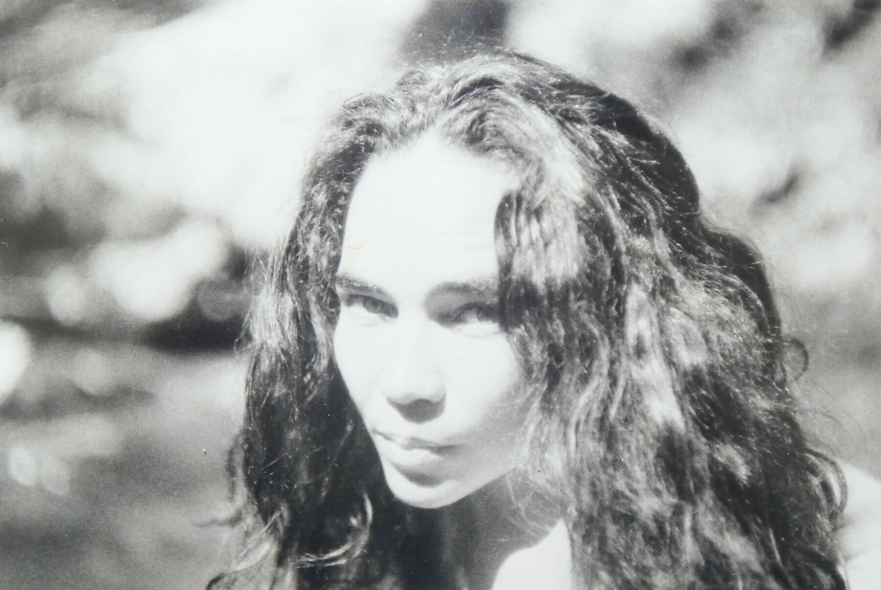 Portrait en noir et blanc d’une femme aux cheveux longs ondulés